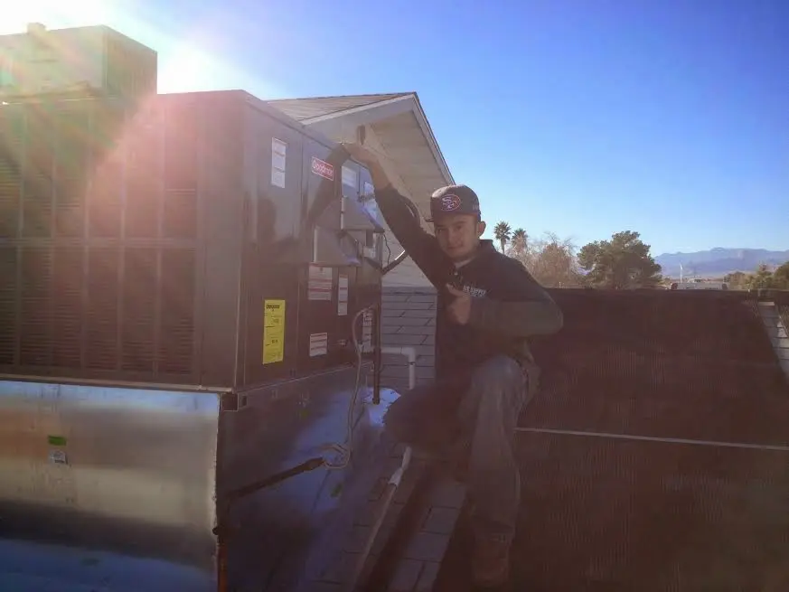 HVAC technician performing Air Duct Repair on a rooftop unit in Valley Center